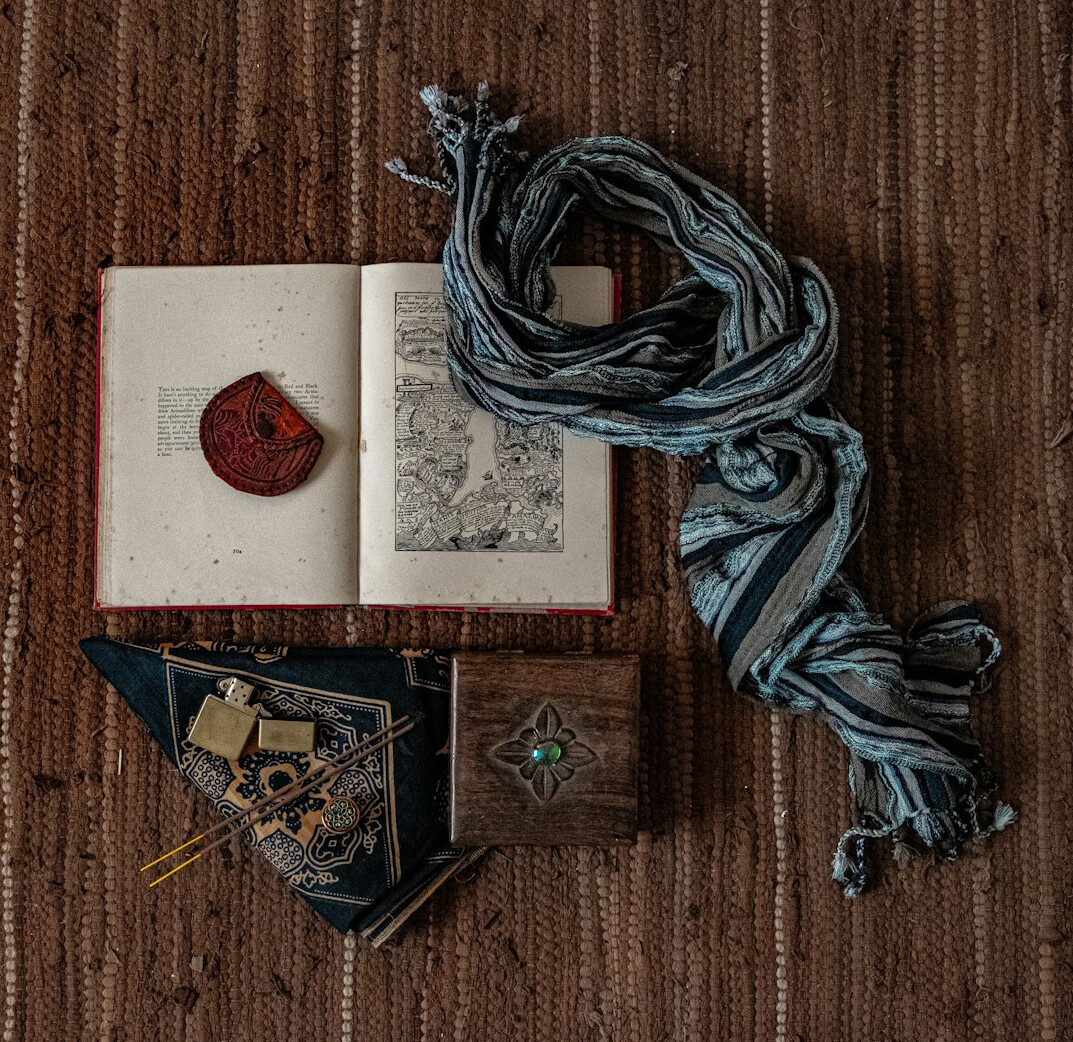 Old leather-bound books and an antique compass on a wooden table