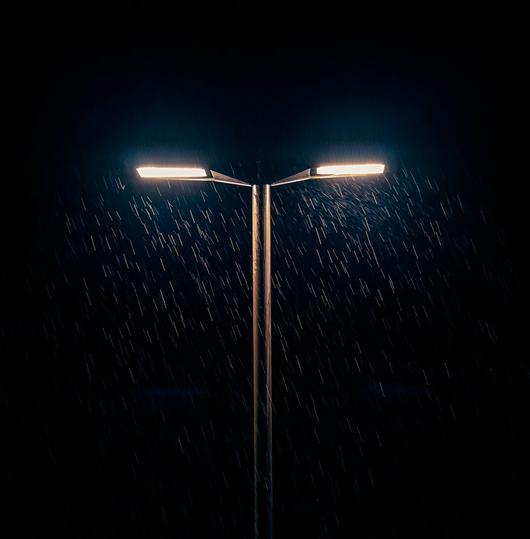 Rainy cobblestone street in Montevideo at night with glowing streetlights